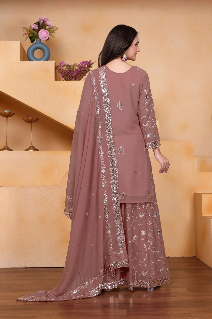 Woman wearing a mauve traditional outfit with floral patterns in a well-lit room.
